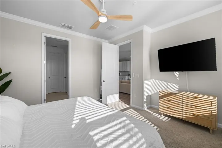 Bedroom featuring crown molding, carpet floors, and a ceiling fan