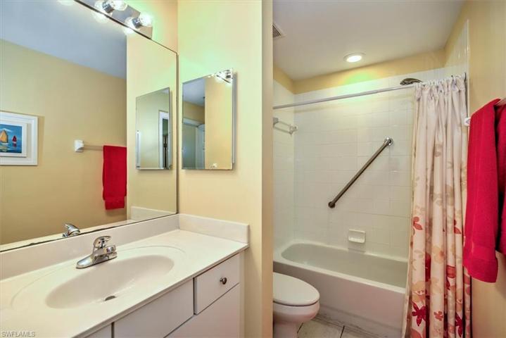 Main bathroom with tiled tub walls, grab bar & interior linen closet!