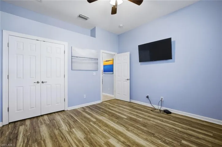 Unfurnished bedroom with wood finished floors, a closet, and ceiling fan
