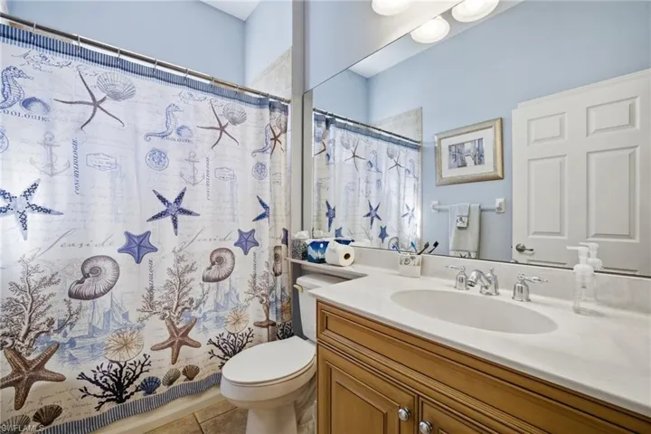 Bathroom with a shower with curtain, vanity, and light tile patterned floors