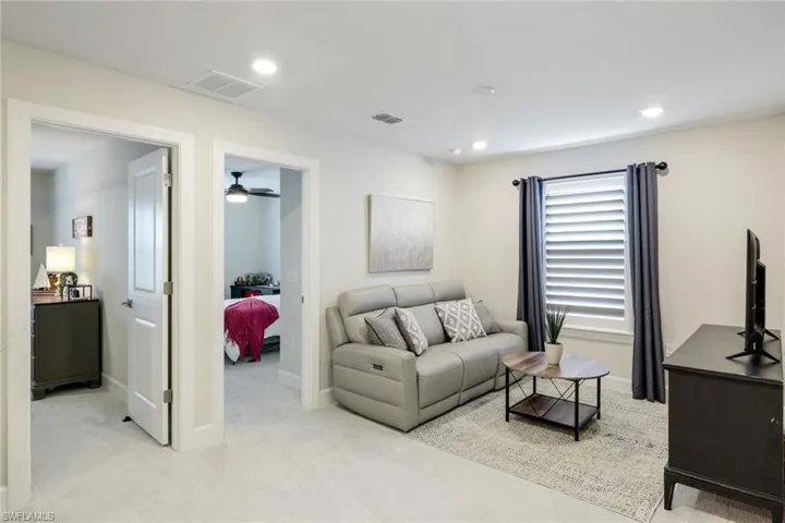 Living room featuring light colored carpet and ceiling fan