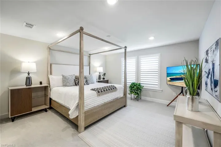 Bedroom featuring light colored carpet