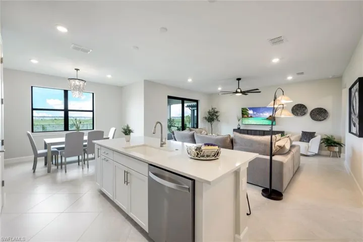 Kitchen featuring a healthy amount of sunlight, sink, a center island with sink, and stainless steel dishwasher