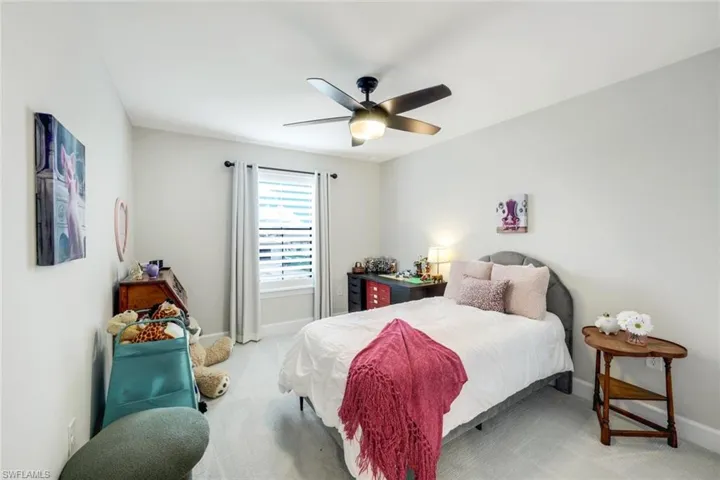 Carpeted bedroom featuring ceiling fan