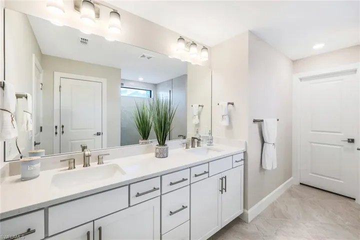 Bathroom with tile flooring and double vanity