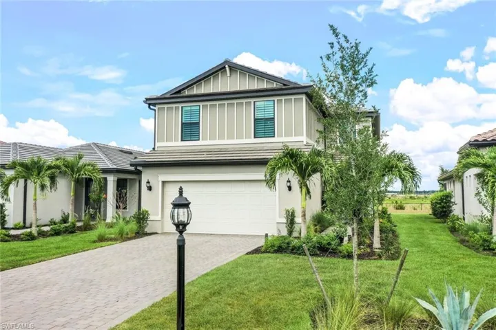View of front of house with a garage and a front lawn