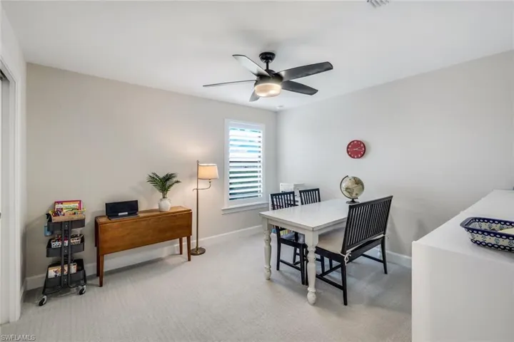Carpeted dining area featuring ceiling fan