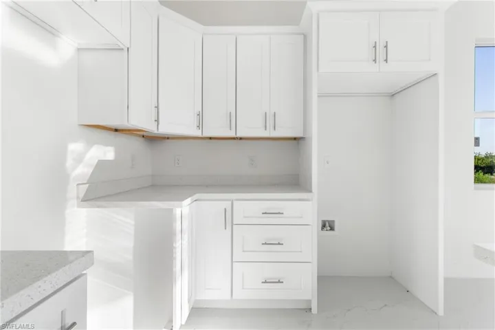 Laundry room with light marble finish floors