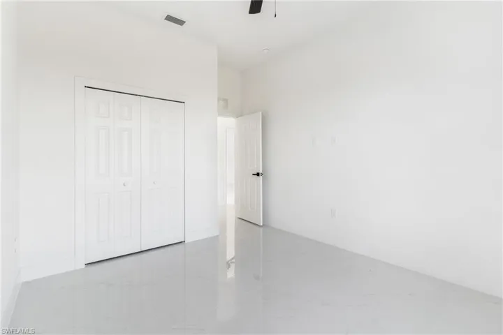 Unfurnished bedroom with marble finish floors, baseboards, a closet, and a ceiling fan