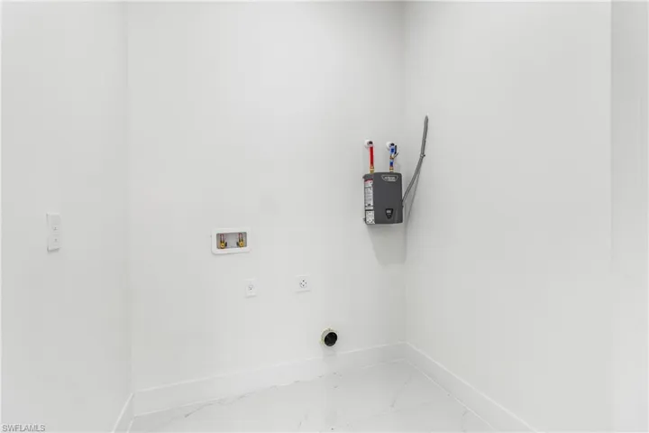 Laundry room with hookup for an electric dryer, light marble finish flooring, baseboards, and hookup for a washing machine