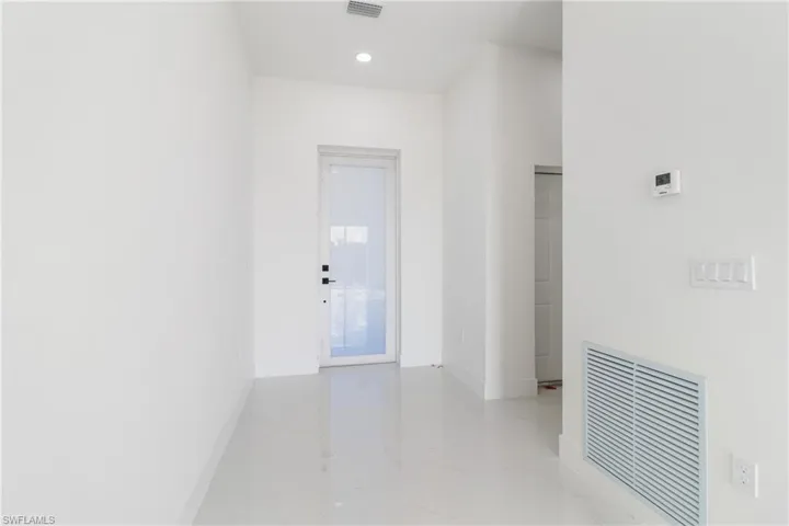 Hall featuring baseboards, recessed lighting, and light marble finish floors