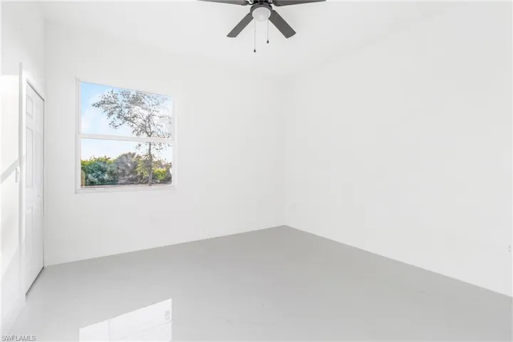 Empty room with a ceiling fan and marble finish floors