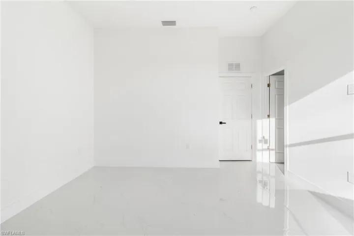 Empty room featuring marble tiled floors and baseboards
