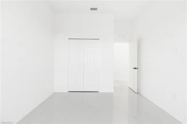Spare room with light marble finish flooring and baseboards