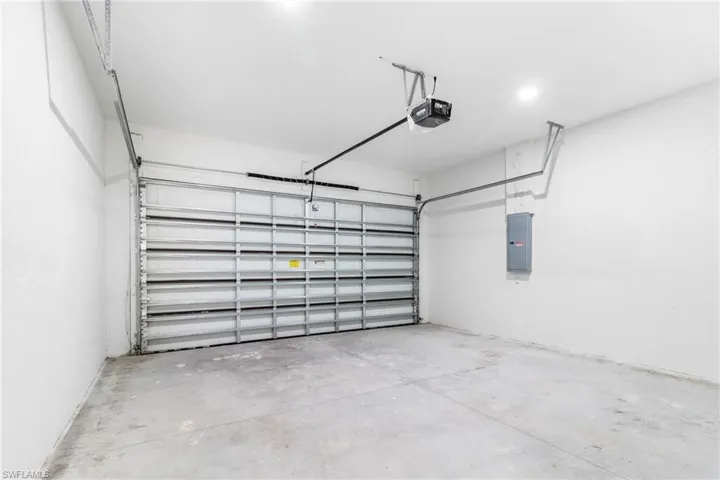 Garage featuring electric panel and a garage door opener