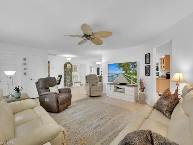 Living room featuring tile patterned floors and ceiling fan