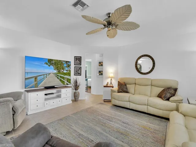 Living room with light tile patterned flooring and ceiling fan