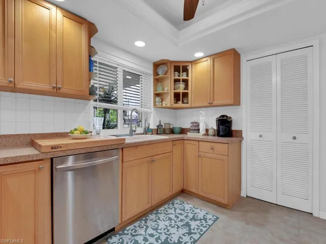 Kitchen featuring dishwasher, tasteful backsplash, sink, and ornamental molding