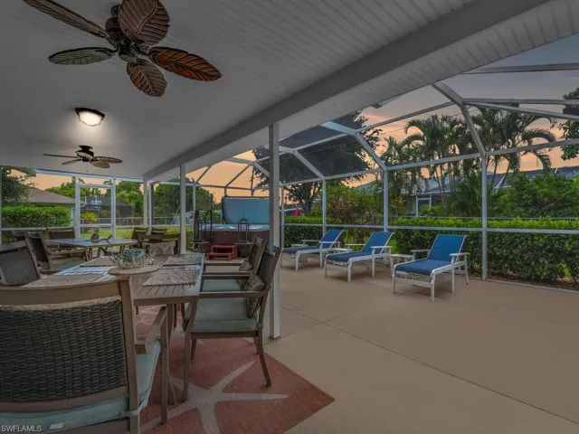 Patio terrace at dusk featuring outdoor lounge area, ceiling fan, and a lanai