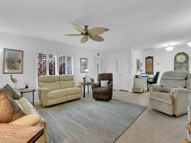 Living room with light tile patterned floors and ceiling fan
