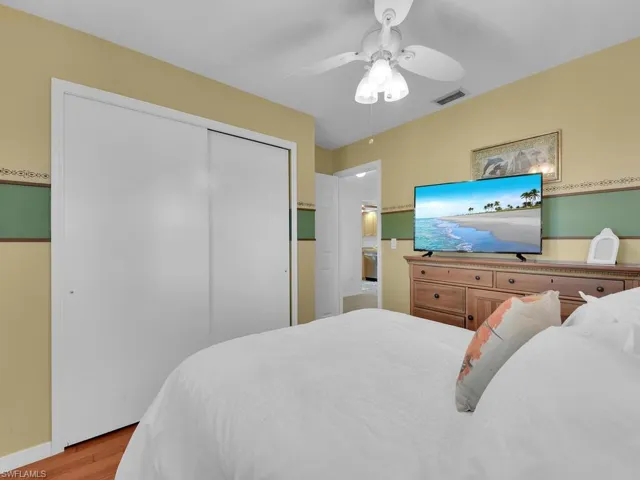 Bedroom with light hardwood / wood-style floors, a closet, and ceiling fan