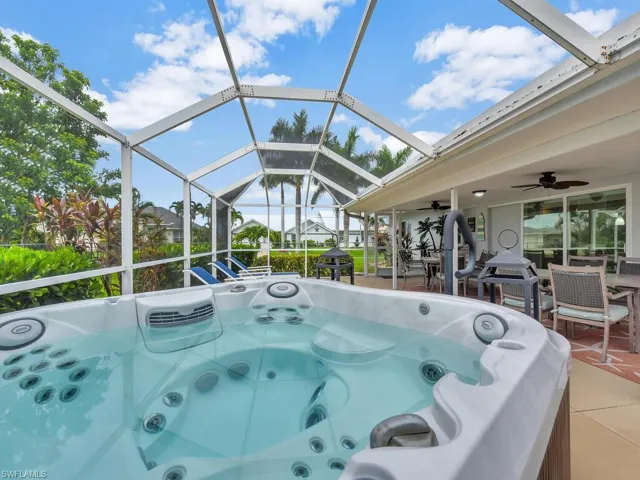 View of pool featuring a patio area, a hot tub, a lanai, and ceiling fan