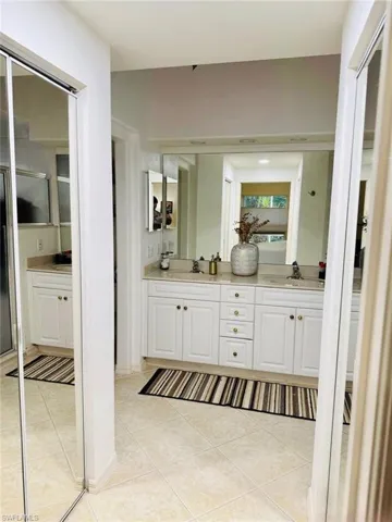 Bathroom with double vanity and light tile patterned floors
