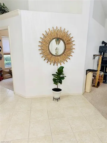 Hallway featuring light colored carpet and light tile patterned floors