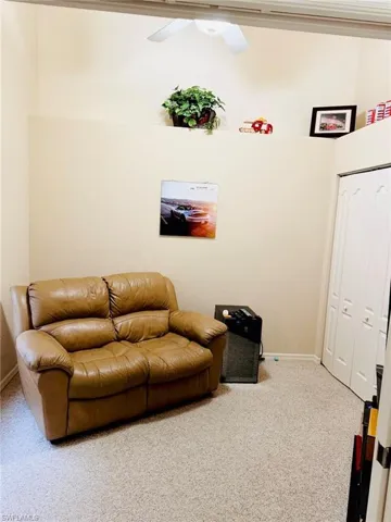 Living room featuring carpet and ceiling fan