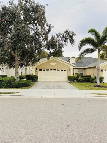 View of front facade with concrete driveway, an attached garage, and stucco siding
