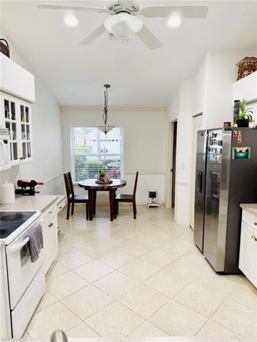Kitchen featuring white appliances, white cabinetry, pendant lighting, recessed lighting, and light stone countertops