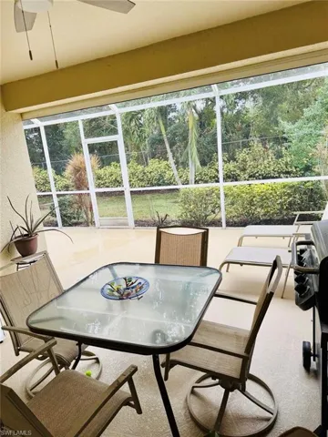Sunroom / solarium with carpet and view of wooded area