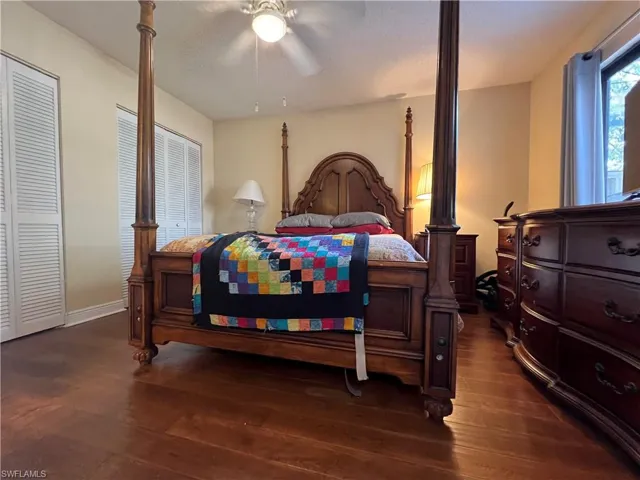 Bedroom featuring wood flooring, two closets, and ceiling fan