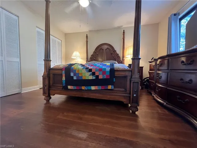 Bedroom with ceiling fan and dark hardwood / wood-style flooring