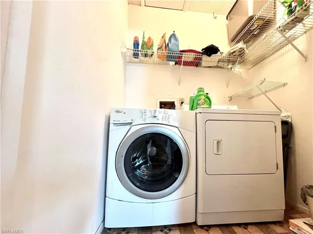 Clothes washing area with hardwood / wood-style flooring and independent washer and dryer