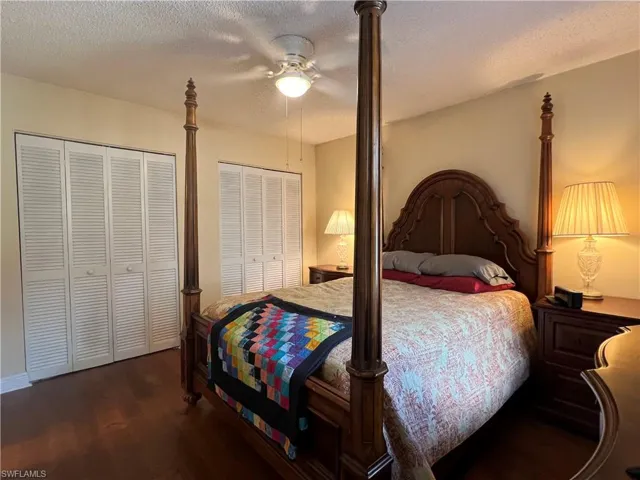 Bedroom featuring multiple closets, dark hardwood / wood floors, ceiling fan