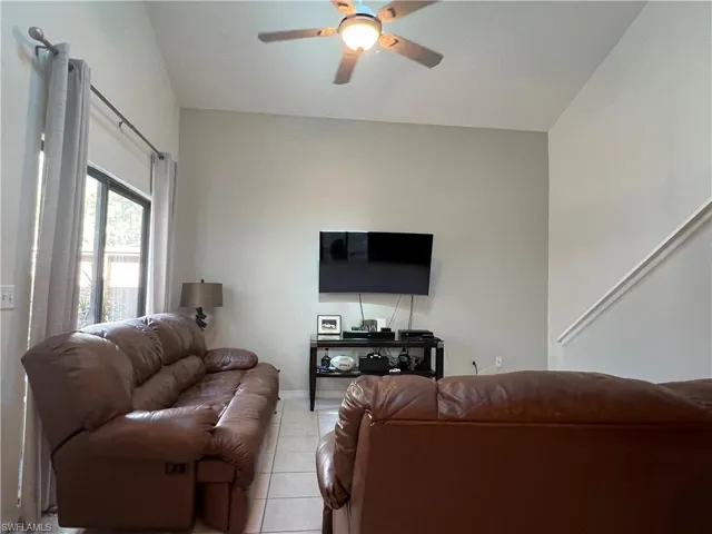 Living room featuring light tile patterned flooring and ceiling fan