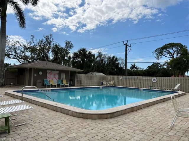 Community pool featuring fence and a patio