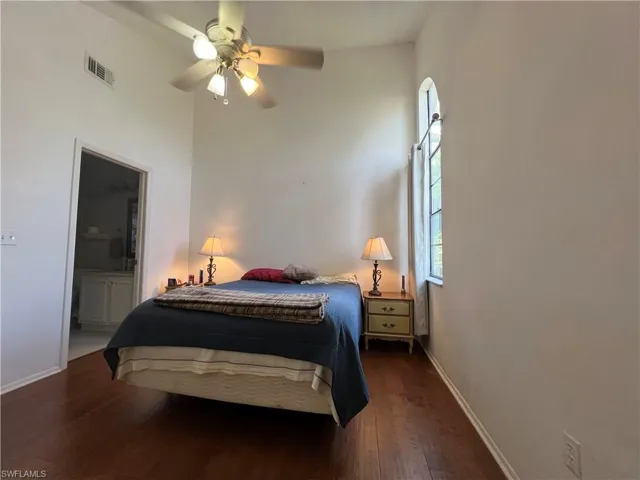 Bedroom with ceiling fan, ensuite bathroom, and hardwood / wood flooring