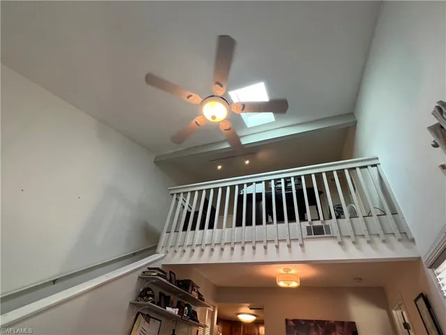 Stairs featuring a skylight, a high ceiling, and ceiling fan