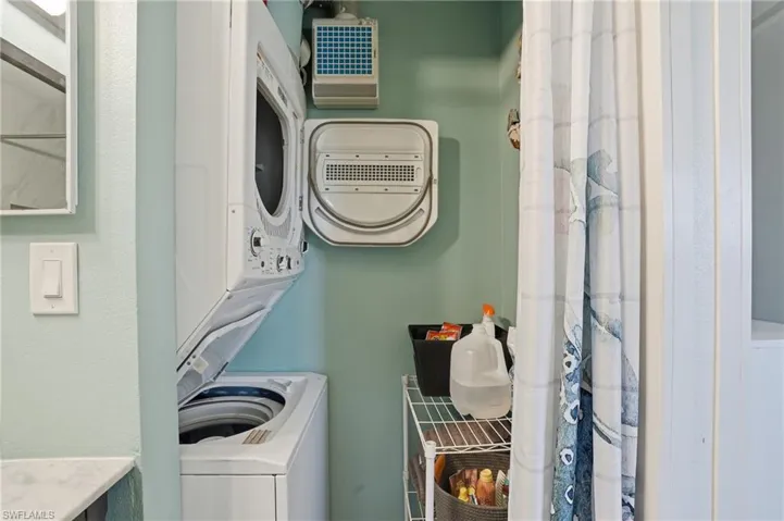 Laundry area with stacked washer and clothes dryer