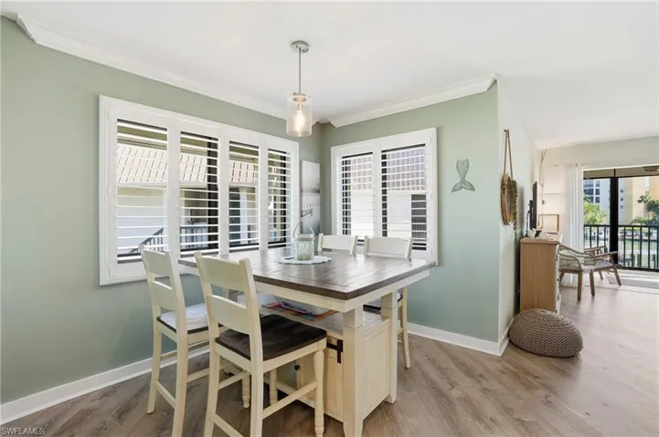 Dining area with light wood finished floors and crown molding