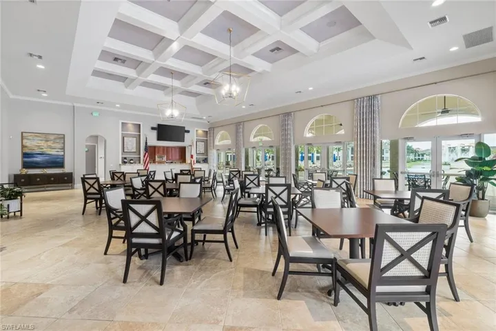 Dining room featuring coffered ceiling, a high ceiling, arched walkways, recessed lighting, and a chandelier