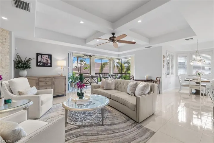 Living area with light tile patterned floors, coffered ceiling, a ceiling fan, beam ceiling, and recessed lighting