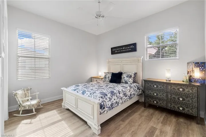 Bedroom featuring wood finished floors, a ceiling fan, and multiple windows