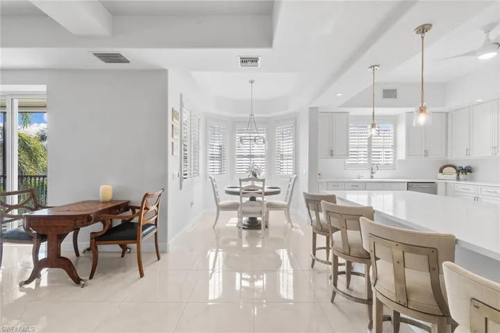 Dining area featuring a tray ceiling and light marble finish floors