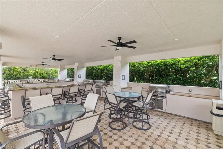 View of patio with an outdoor kitchen, outdoor dining area, and a ceiling fan