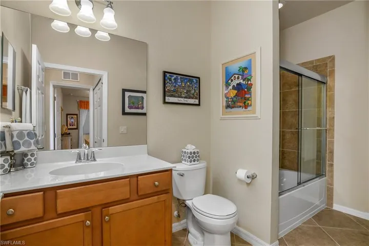 Full bathroom with shower/tub combo with glass enclosure and comfort height toilet