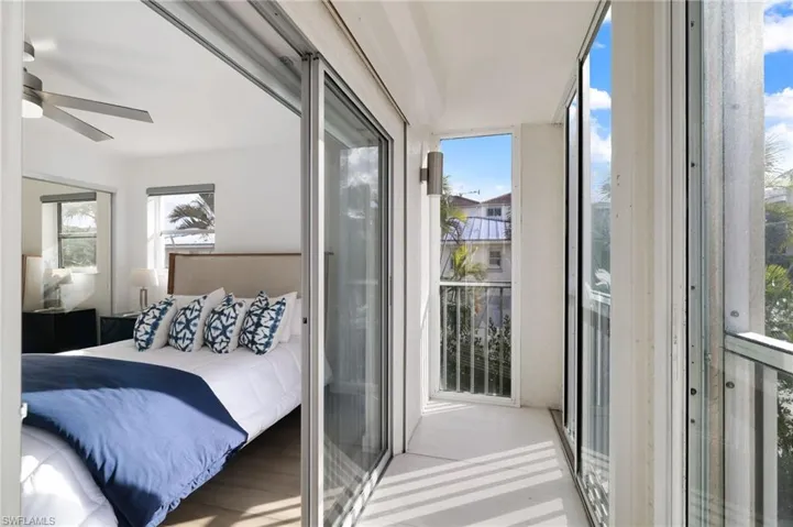 Bedroom with ceiling fan, floor to ceiling windows, and access to outside