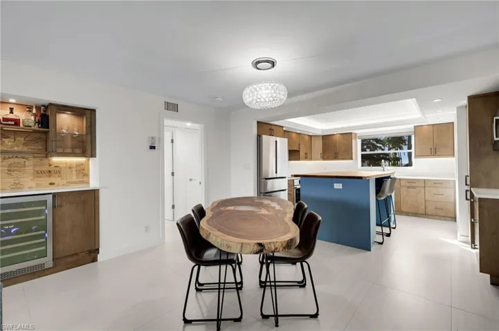 Dining area with beverage cooler, recessed lighting, a bar, and a chandelier